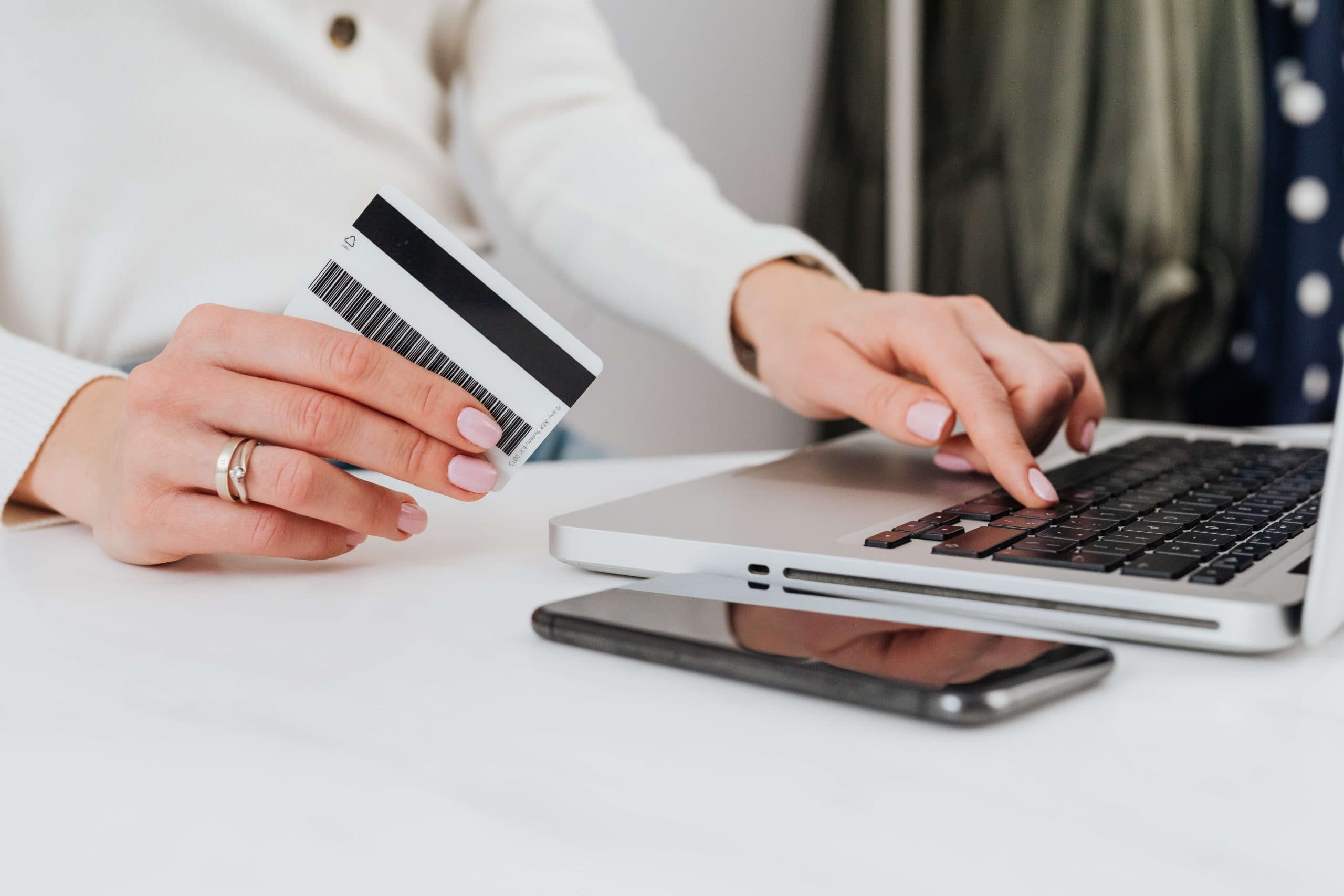 woman typing her credit card information into a laptop